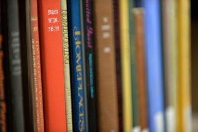Books line a shelf in the Newman Library.