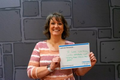 Leigh Anne Byrd, an advisor in the College of Engineering, holds a sign that says, "I advise because I love working with students and helping them reach their goals!"