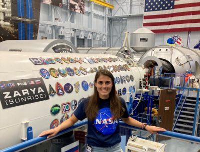 Woman standing in front of space vehicle with other vehicles in background