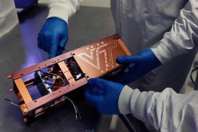 Students make final modifications to their satellite, the Ut ProSat-1. 