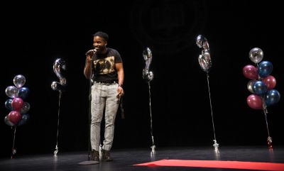 A VTCSOM student announces his match on stage at microphone. 