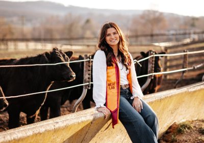 Ashlyn Clemmer in a white shirt with a maroon and orange graduation stole.